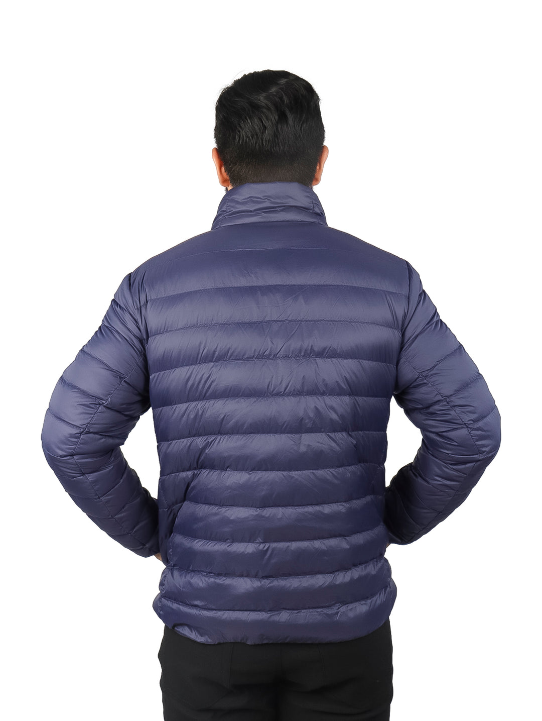 Hombre vistiendo una chamarra acolchada de pluma color azul marino con cuello alto y bolsillos laterales.
