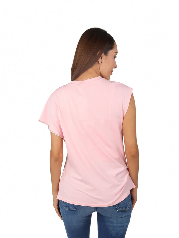 Mujer vistiendo una blusa rosa con detalles de pedrería en el hombro y cuello.