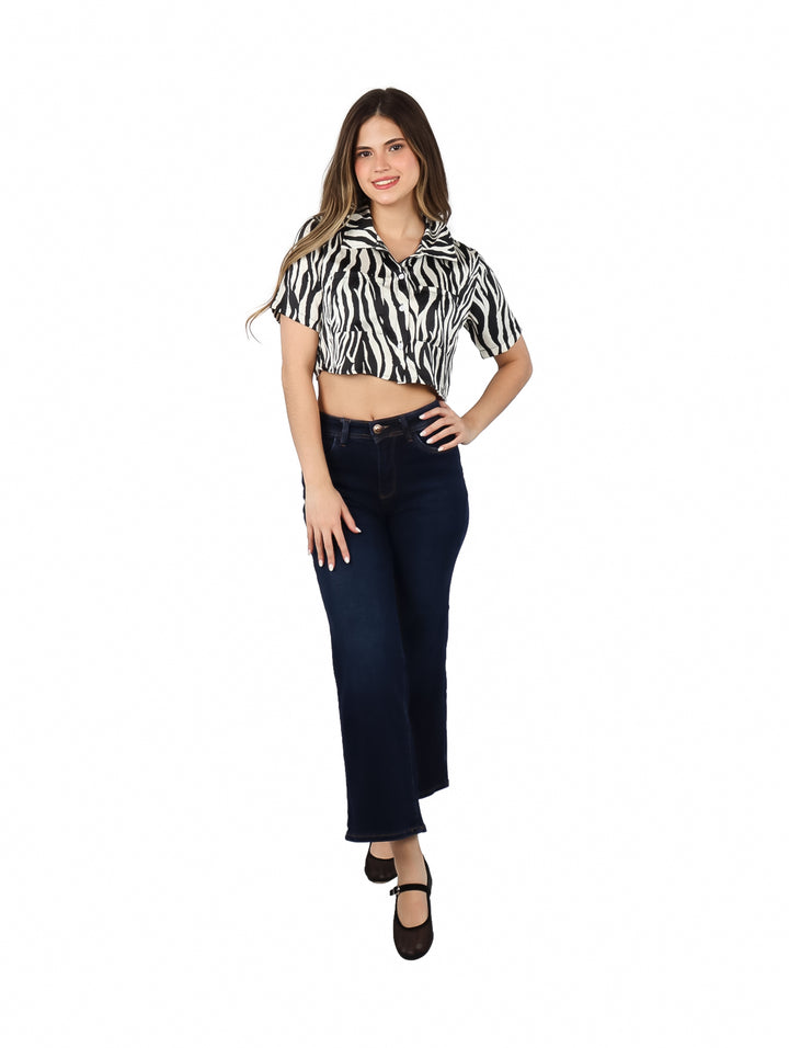 Mujer vistiendo blusa corta de satín con estampado de cebra en colores negro y blanco.