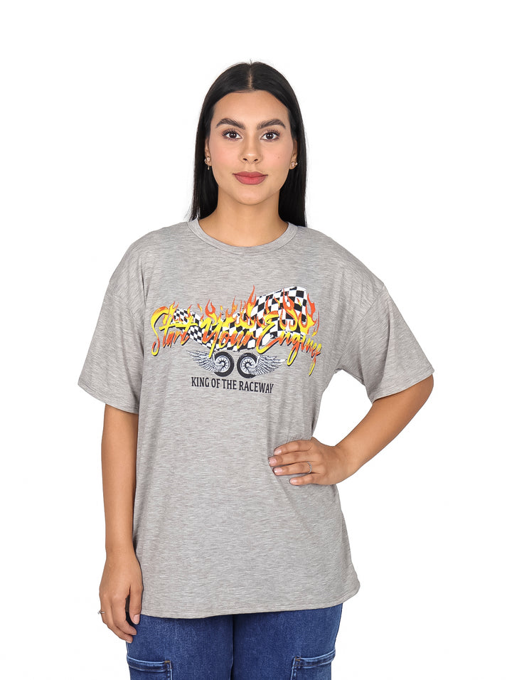 Mujer vistiendo camiseta oversize color gris con estampado gráfico de carreras en el pecho.