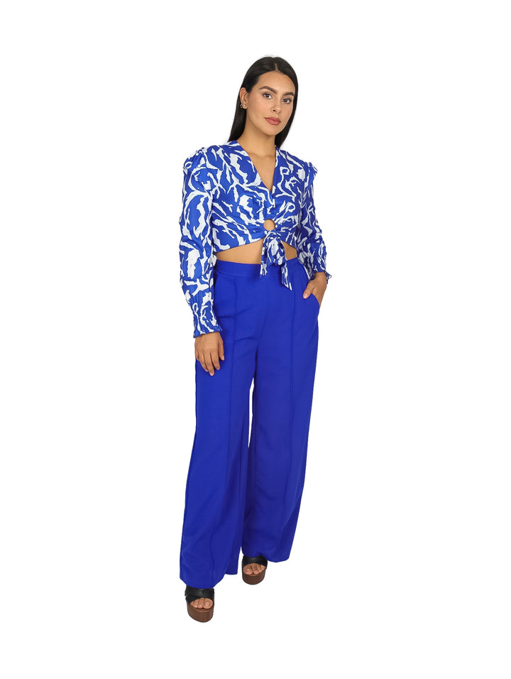 Conjunto de blusa estampada en azul y blanco con pantalón azul de pierna ancha.