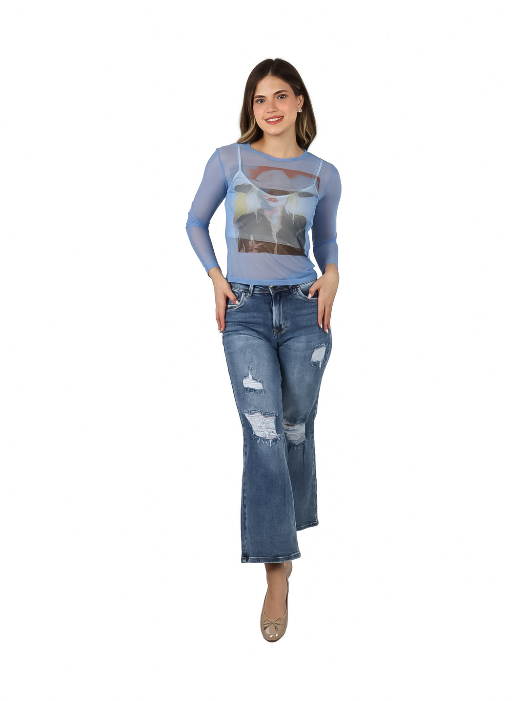 Mujer vistiendo blusa azul transparente de manga larga con estampado gráfico frontal y jeans azules.