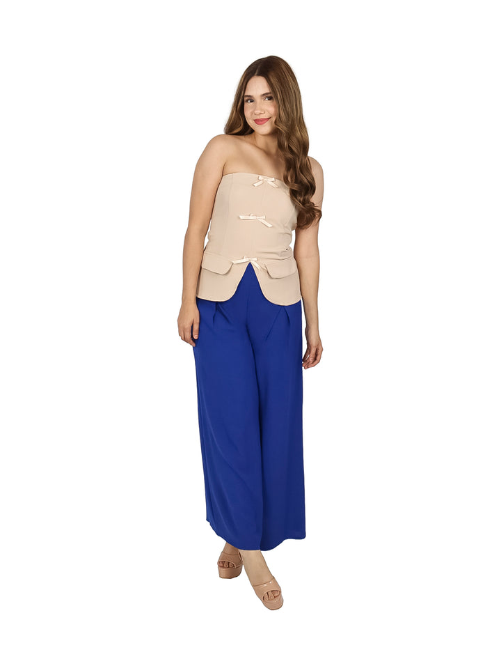 Mujer vistiendo un top strapless color beige con tres moños decorativos al frente.