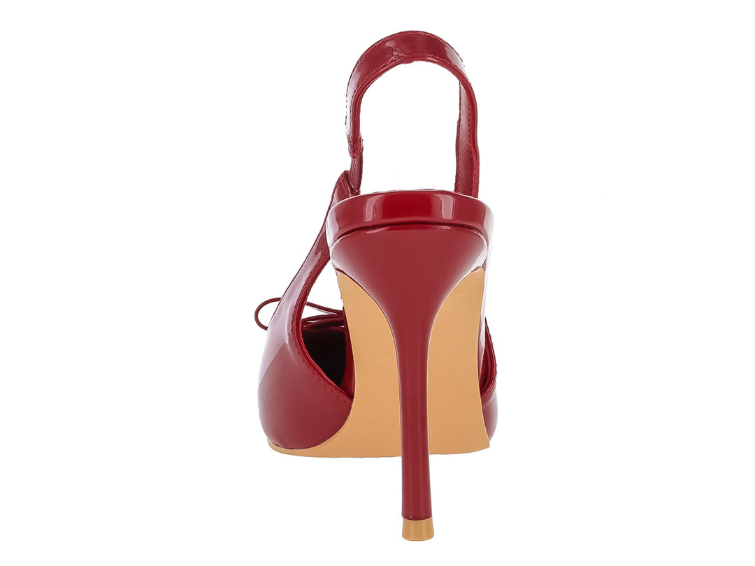Zapato de tacón rojo brillante con punta aguda, detalle de moño y correa posterior.
