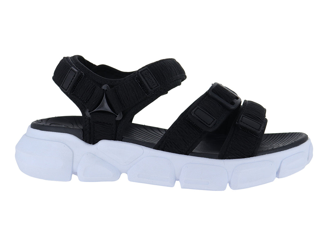 Sandalia negra con suela blanca gruesa y correas ajustables de velcro.