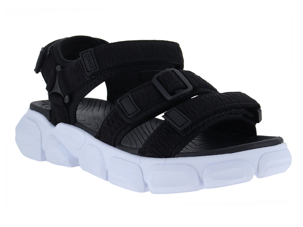 Sandalia negra con suela blanca gruesa y correas ajustables de velcro.