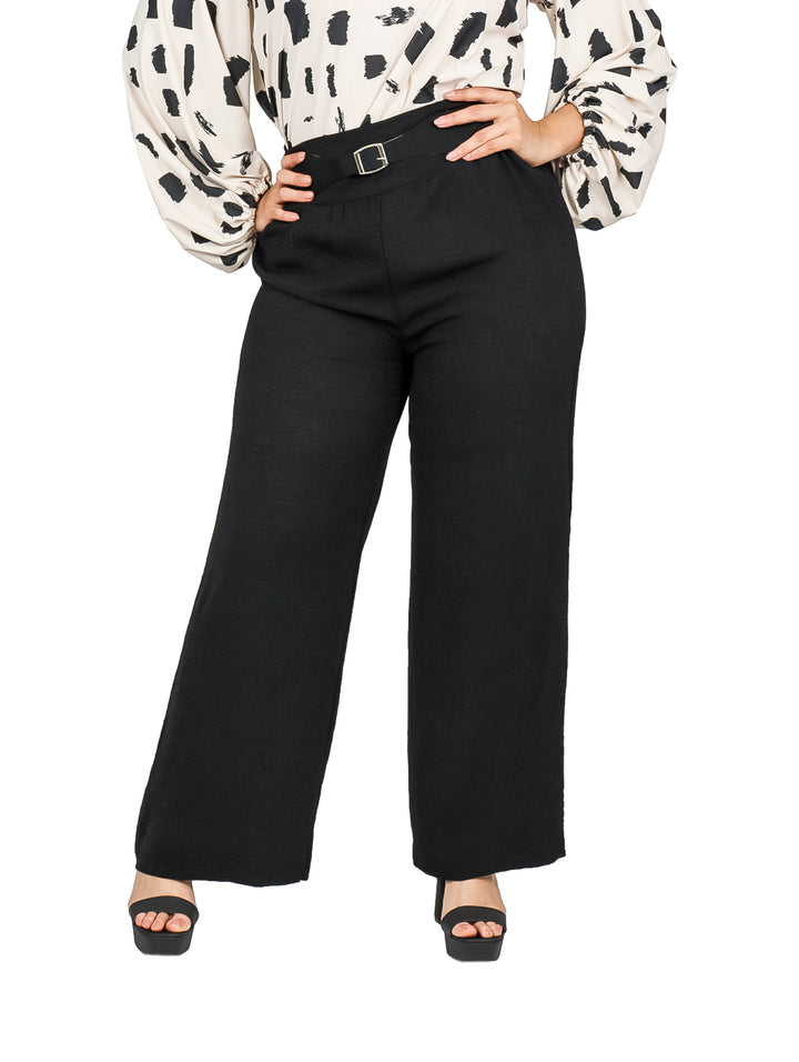 Mujer vistiendo pantalón negro de corte ancho con cinturón integrado.