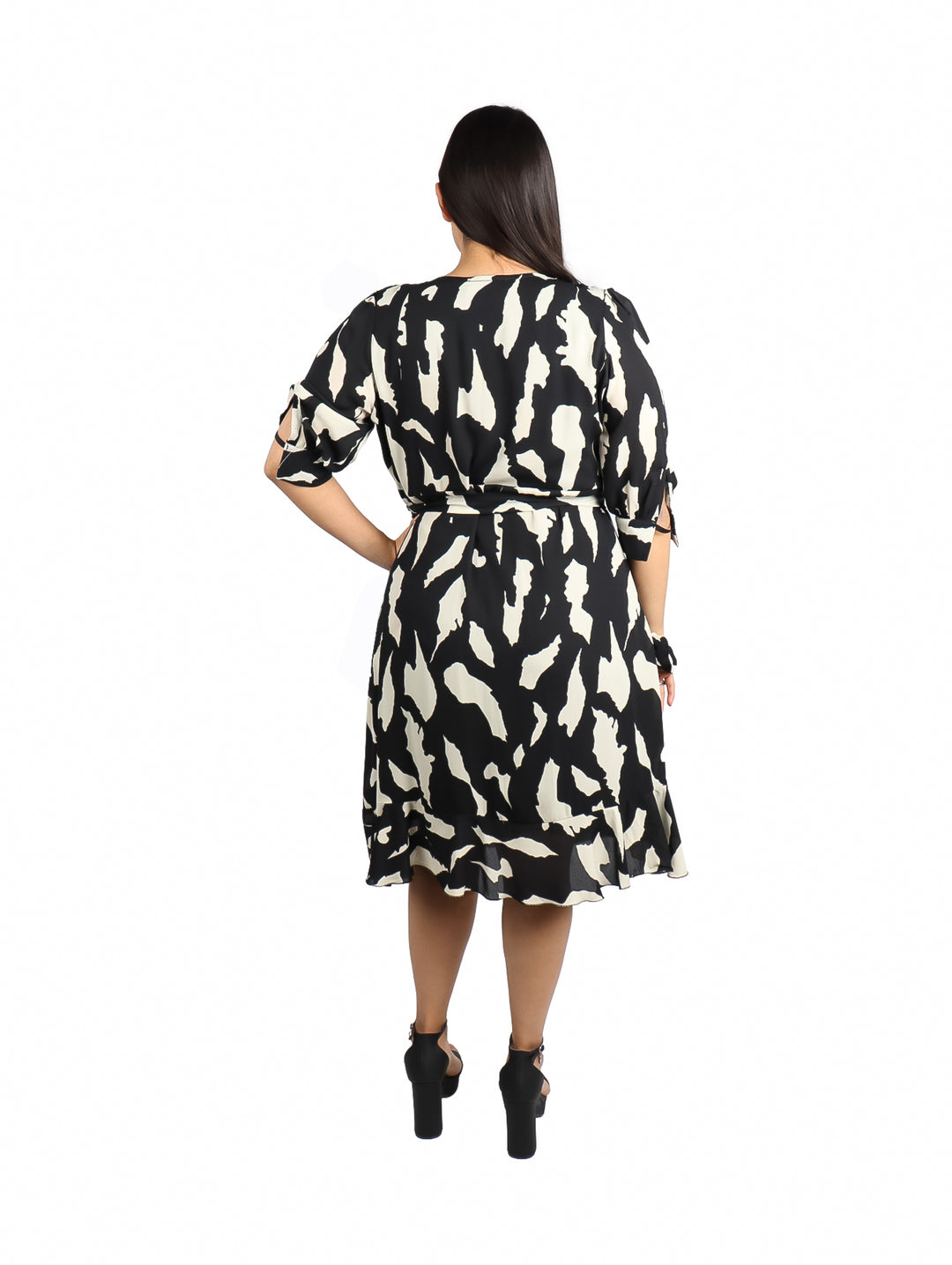Mujer vistiendo un vestido corto de color negro con estampado ivory, manga corta y cuello en V.