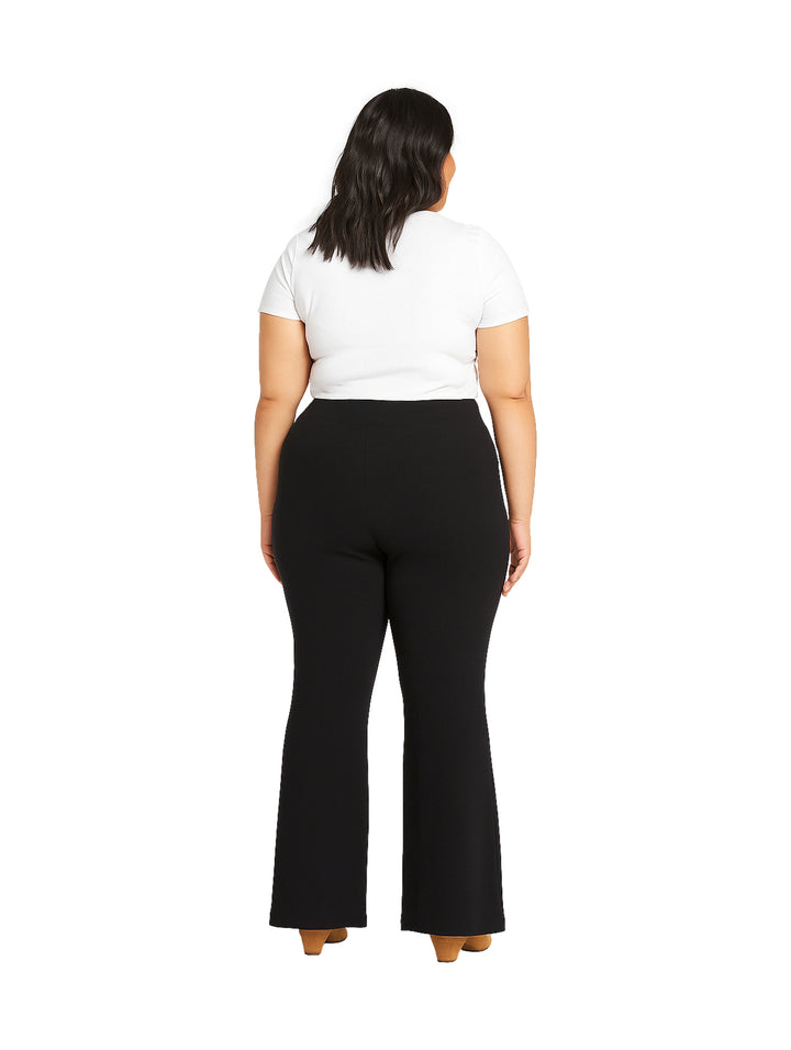 Mujer vistiendo pantalón recto negro de maternidad y camiseta blanca.