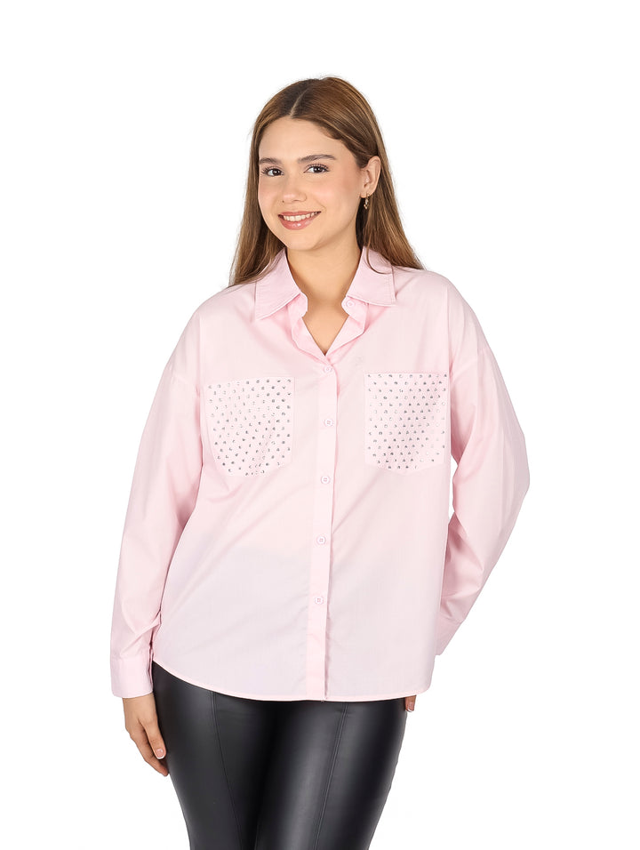 Camisa de popelina color rosa con detalles brillantes en los bolsillos frontales.