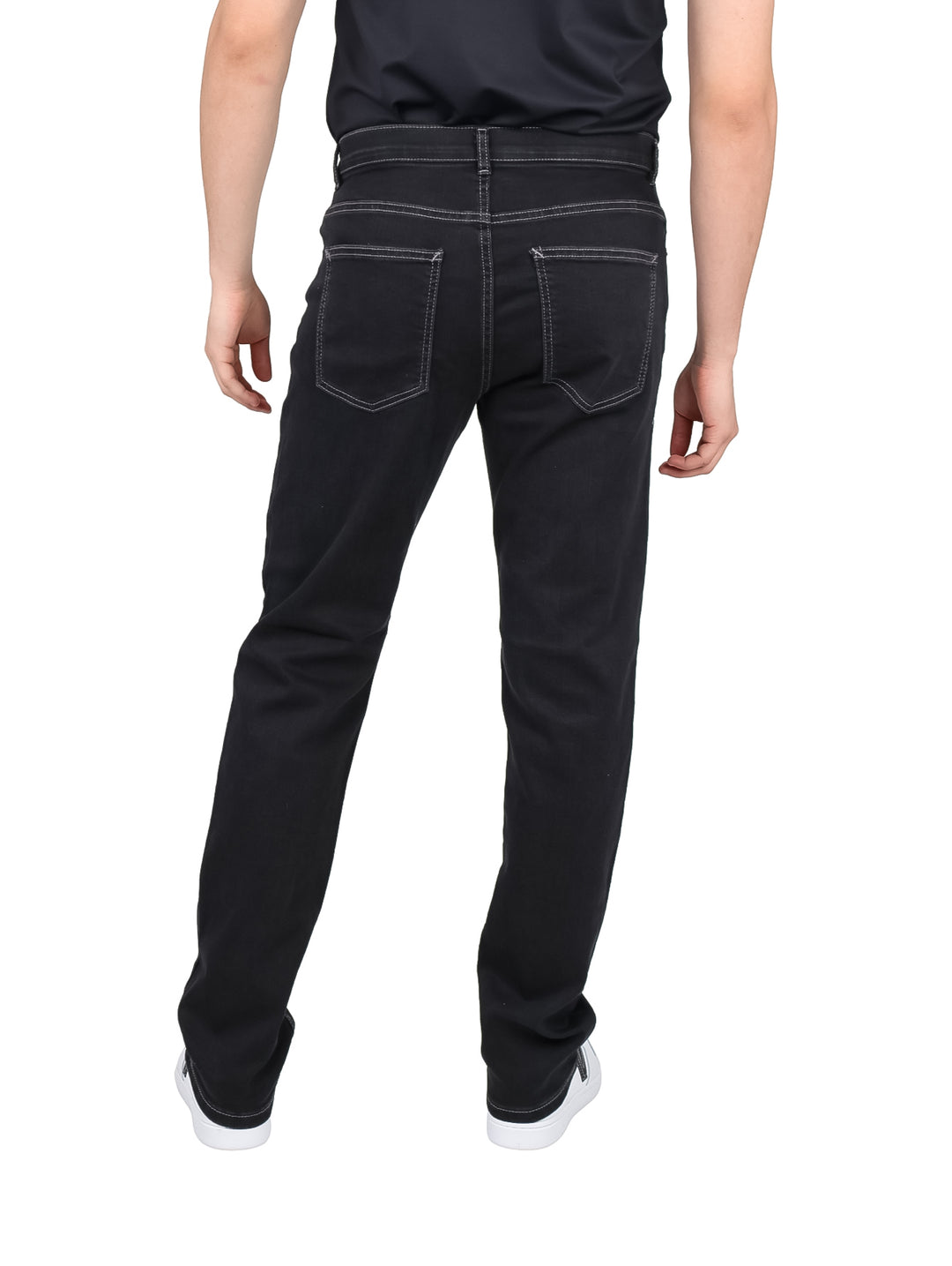 Hombre vistiendo pantalones negros de corte recto con costuras contrastantes y tenis blancos.