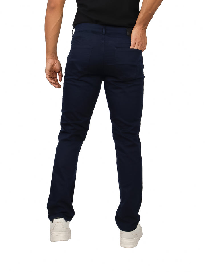 Hombre vistiendo pantalones slim fit color azul marino oscuro y camiseta negra.