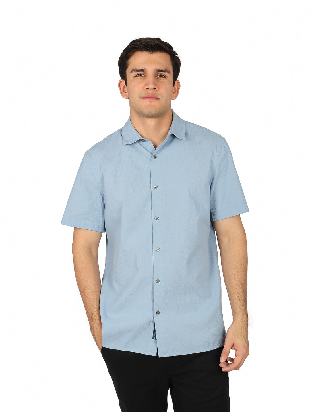 Hombre vistiendo una camisa de manga corta color azul claro con botones y cuello.