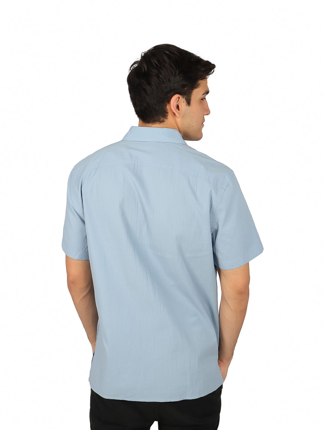 Hombre vistiendo una camisa de manga corta color azul claro con botones y cuello.