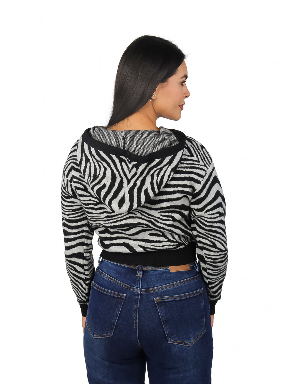 Mujer vistiendo sudadera con capucha y cierre frontal con estampado de zebra en colores negro y blanco.