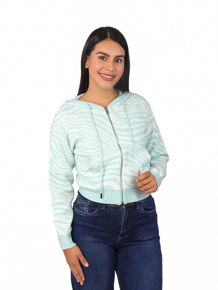 Mujer con sudadera con capucha y cierre frontal, color baby blue con estampado de rayas blancas tipo zebra.