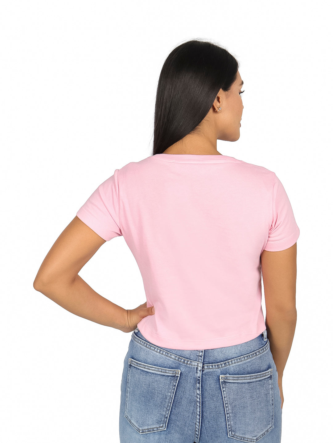 Mujer vistiendo playera rosa de manga corta con logo de K-SWISS en el pecho y pantalones mezclilla azules.