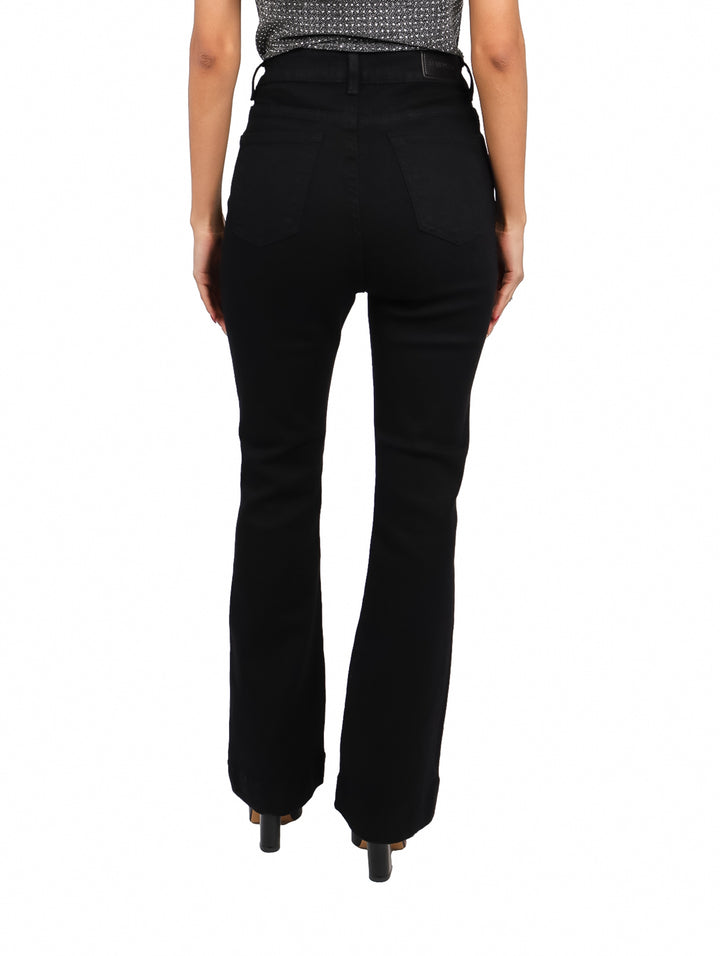 Jeans negros de corte campana para mujer con cierre de botones frontales en color plateado.