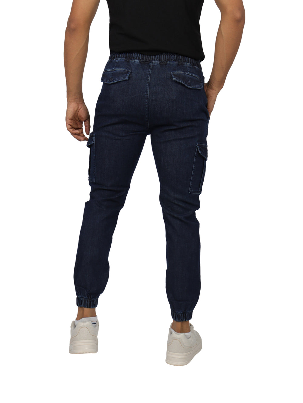 Hombre vistiendo pantalones jogger de mezclilla azul marino con bolsillos cargo y cintura elástica.