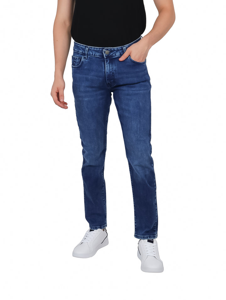 Hombre vistiendo pantalones jeans slim de color azul con efecto de lavado.