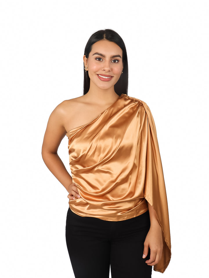 Mujer vistiendo blusa asimétrica satinada color camel de un solo hombro.