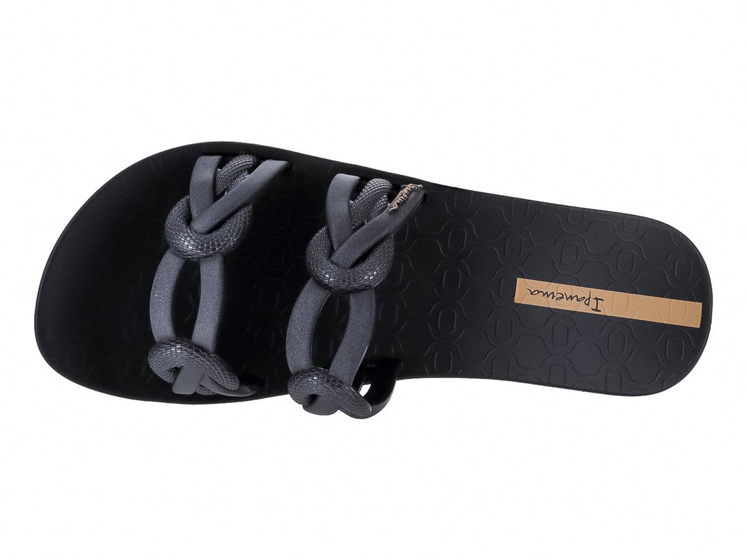Sandalia slide Ipanema color negro y plata con correas entrelazadas en forma de nudo.