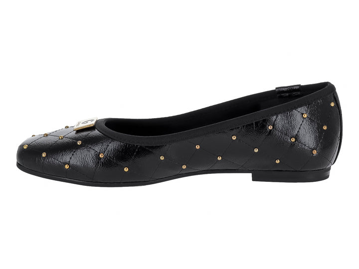 Zapato plano negro con diseño acolchado y tachuelas doradas decorativas.