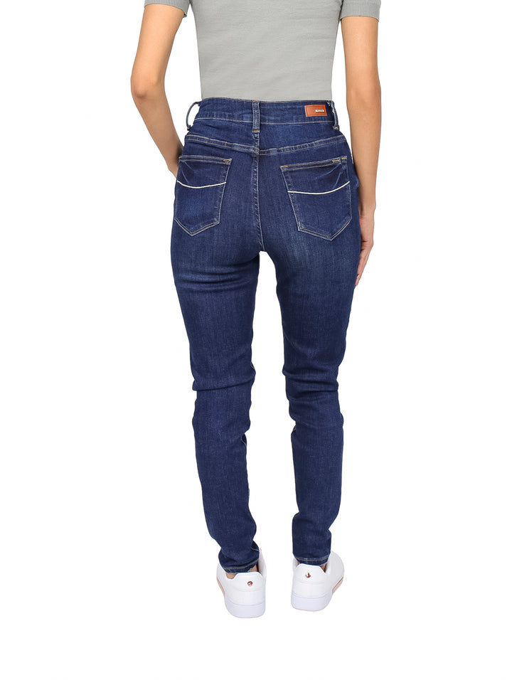 Mujer vistiendo pantalones jeans skinny de color azul oscuro y cintura alta.