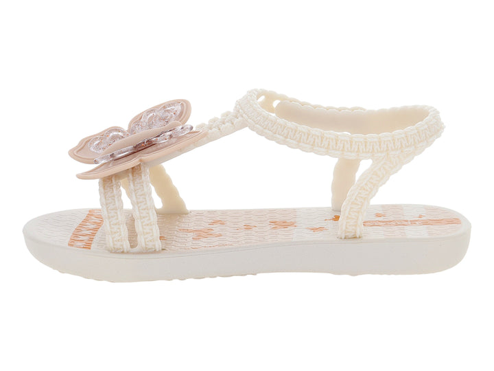 Sandalias para bebé de color beige con adorno de flor y tiras texturizadas.
