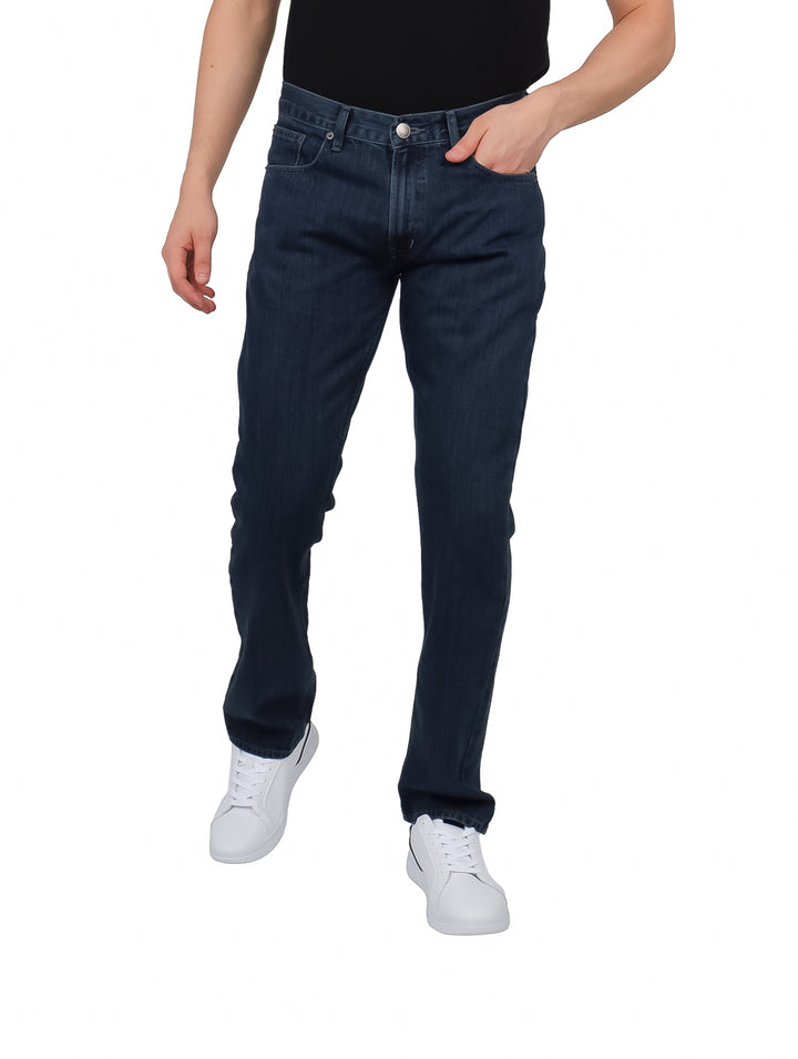 Hombre vistiendo pantalones jeans color carbon de corte recto y estilo casual.