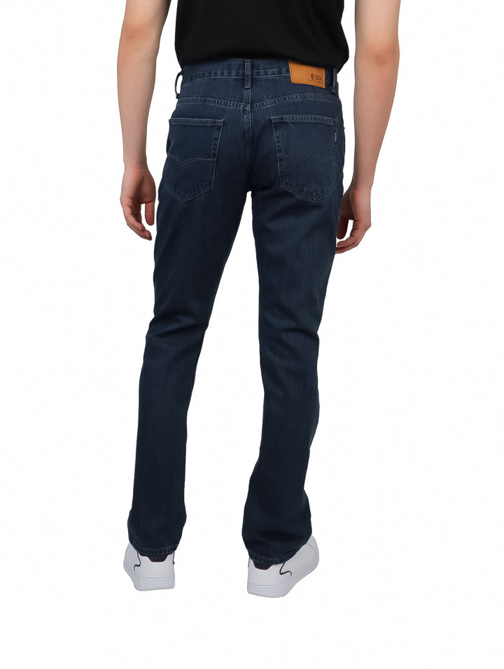 Hombre vistiendo pantalones jeans color carbon de corte recto y estilo casual.
