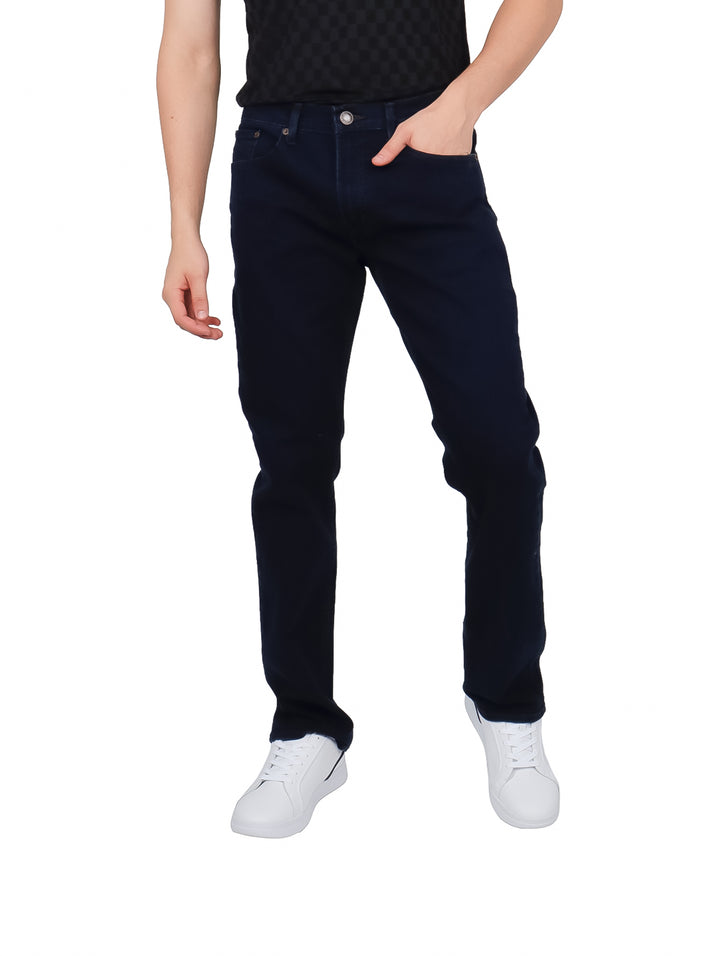 Hombre vistiendo pantalones jeans color azul marino oscuro y tenis blancos.