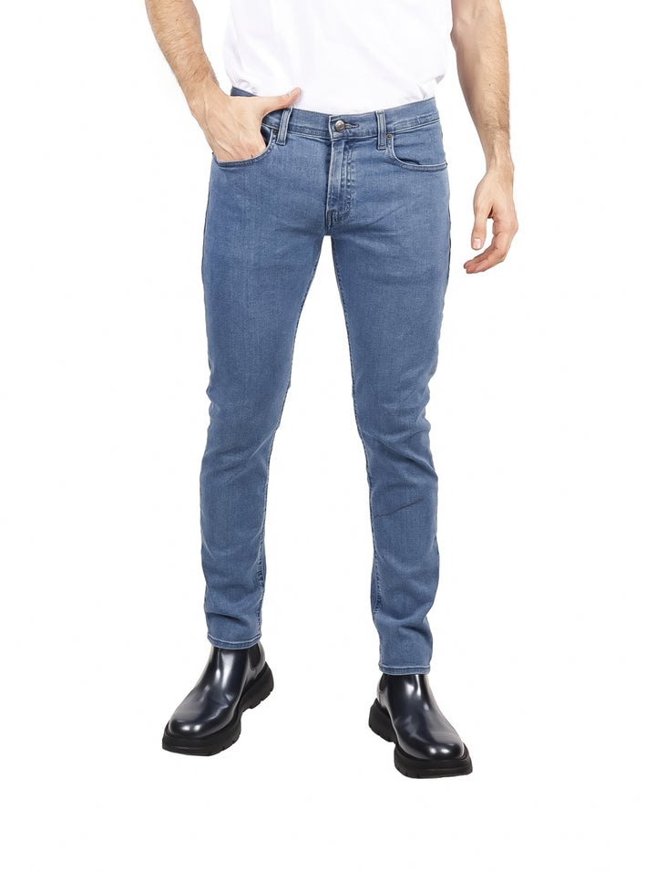 Hombre vistiendo pantalones jeans color azul claro de corte ajustado.