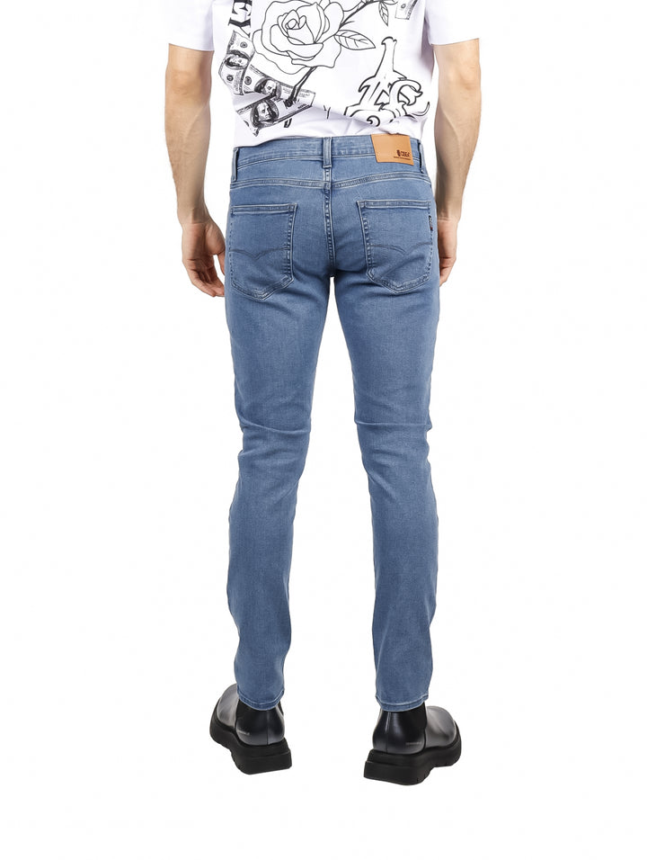 Hombre vistiendo pantalones jeans color azul claro de corte ajustado.