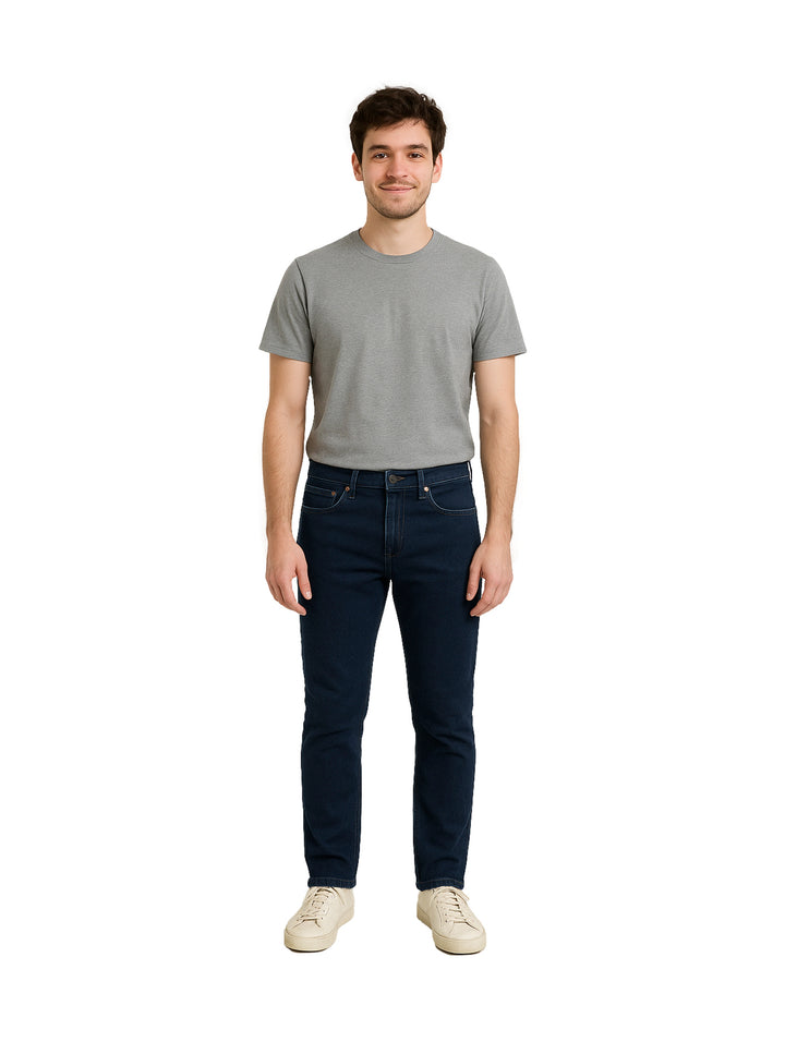 Hombre vistiendo pantalones jeans color azul marino oscuro de corte casual.