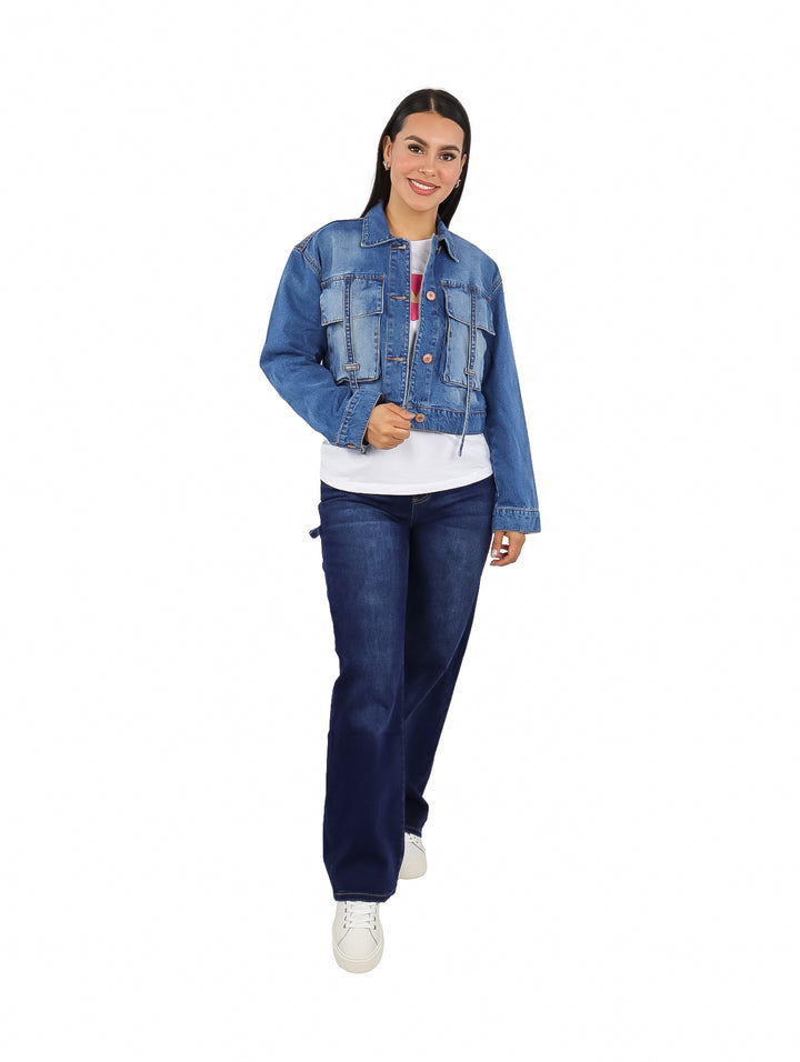 Mujer vistiendo una chamarra corta de mezclilla azul con botones frontales.