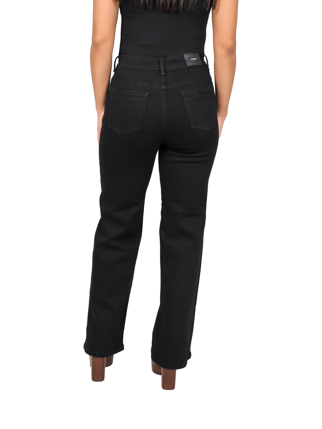 Mujer vistiendo pantalones jeans negros de corte recto con detalles de piedras brillantes.