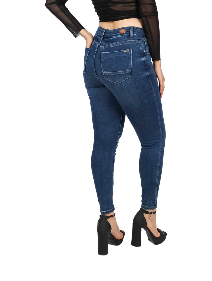 Mujer vistiendo pantalones jeans skinny de color azul oscuro y cintura alta.