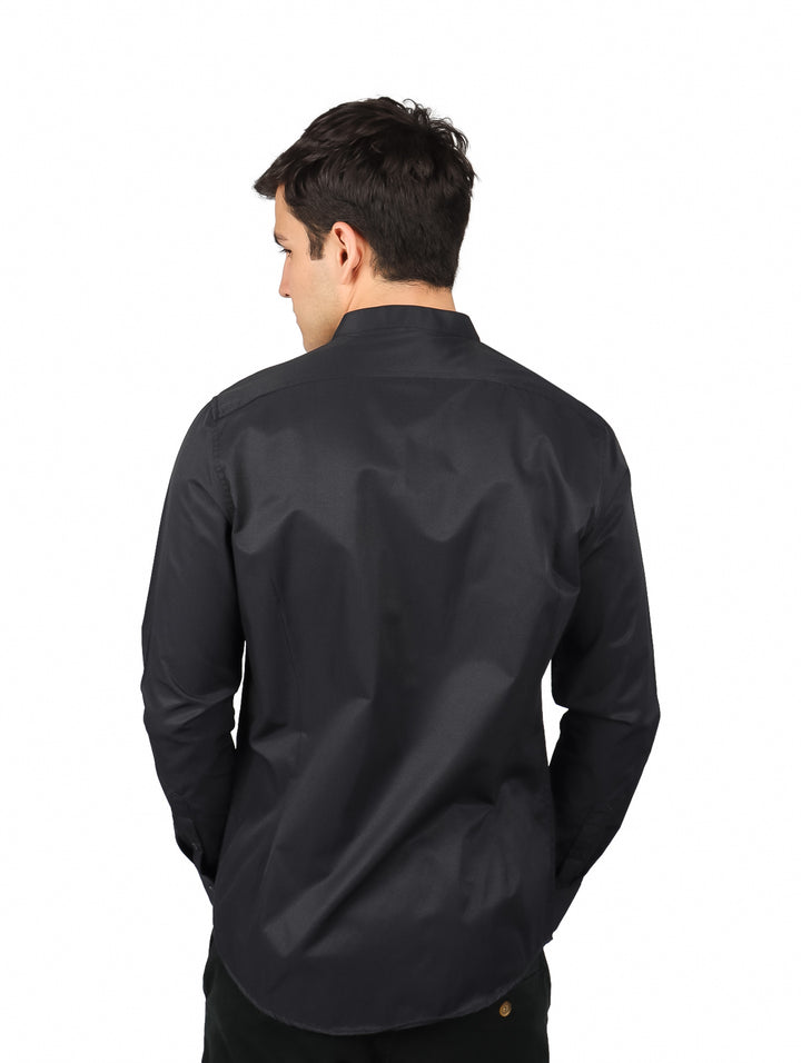 Hombre vistiendo camisa negra de manga larga con cuello mao y acabado brillante.