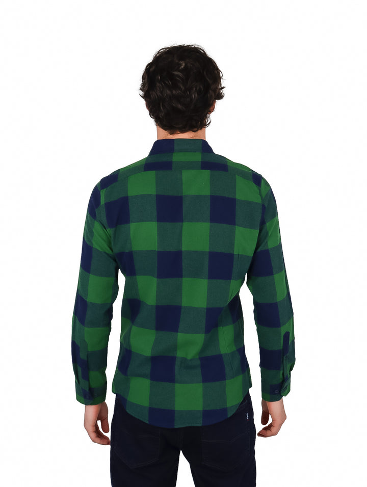 Hombre vistiendo una camisa de cuadros en colores verde y azul marino con manga larga.