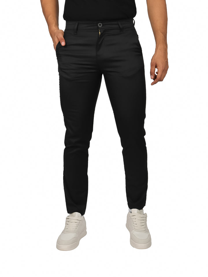 Hombre vistiendo un pantalón de gabardina color negro de corte ajustado.