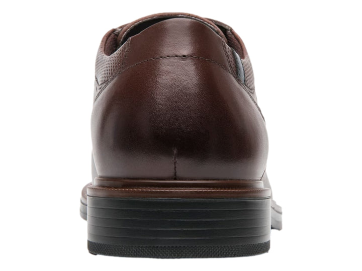 Zapato formal de cuero color nogal con detalles perforados y cordones.