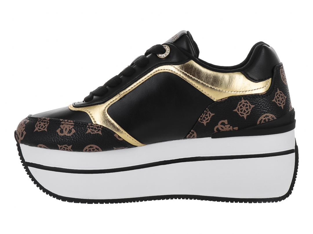 Tenis negros de plataforma Guess con detalles dorados y suela blanca gruesa.
