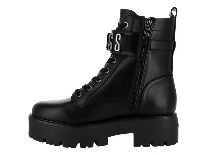 Bota negra de plataforma con suela track, agujetas y detalle de hebilla plateada en el tobillo.