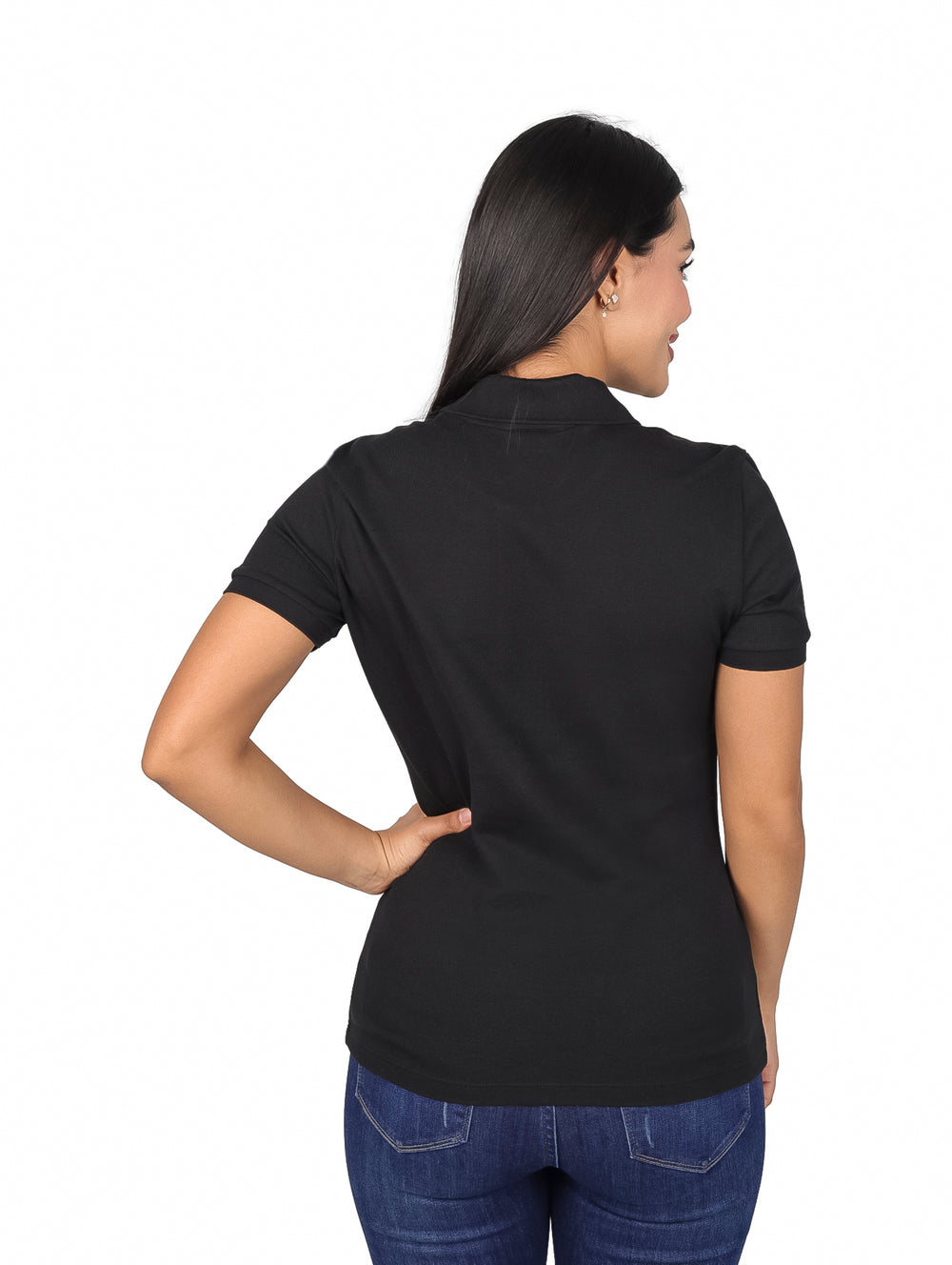 Mujer vistiendo una playera polo Lacoste de color negro y jeans azules.
