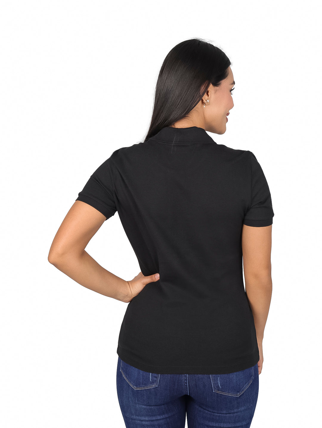 Mujer vistiendo una playera polo Lacoste de color negro y jeans azules.