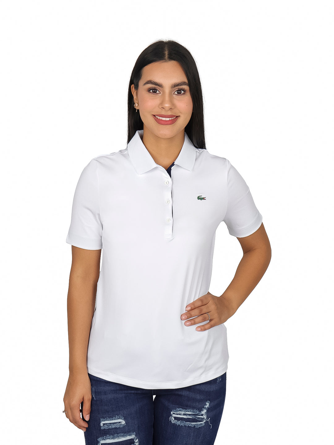 Mujer vistiendo polo blanco de manga corta marca Lacoste con detalles en azul marino en el cuello.