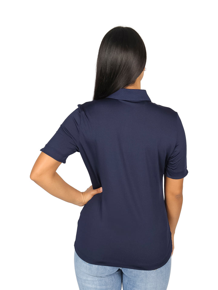 Mujer vistiendo polo azul marino de manga corta con cuello y logo de Lacoste.