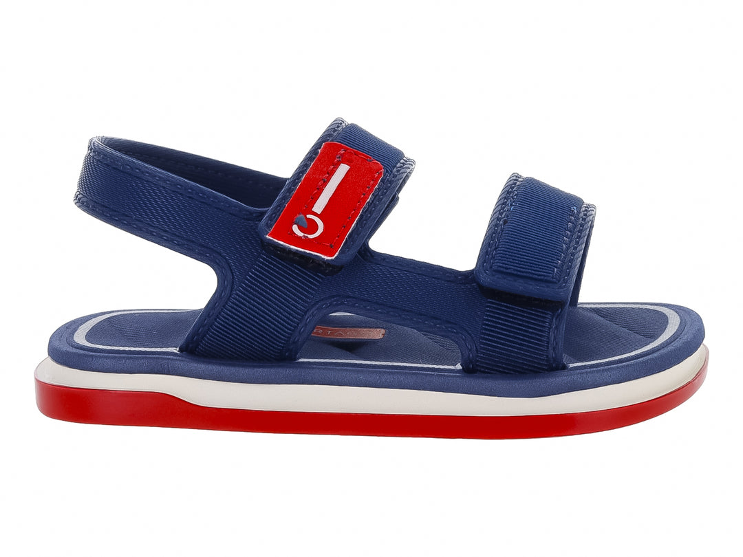 Sandalia infantil Cartago color azul con suela roja y blanca y cierres de velcro.