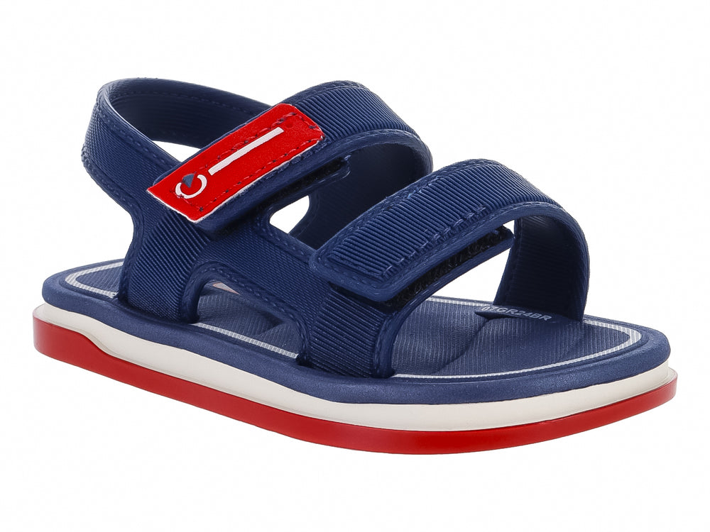 Sandalia infantil Cartago color azul con suela roja y blanca y cierres de velcro.